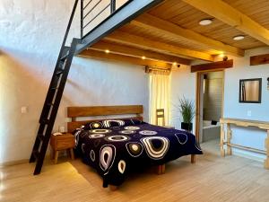 a bedroom with a black and white bed and a staircase at Cabaña Oso Tapalpa in Tapalpa