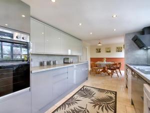 a kitchen with white cabinets and a dining table at Ingleside in Westbury on Severn