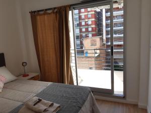 a bedroom with a bed and a large window at BELGRANO LUMINOSO Y AMPLIO DEPARTAMENTO in Buenos Aires
