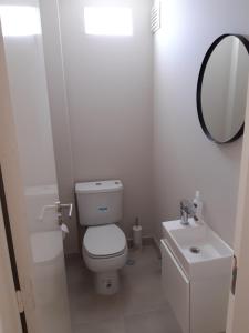 a white bathroom with a toilet and a sink at BELGRANO LUMINOSO Y AMPLIO DEPARTAMENTO in Buenos Aires