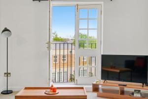 a living room with a tv and a large window at Stylish Central York Duplex Penthouse in York