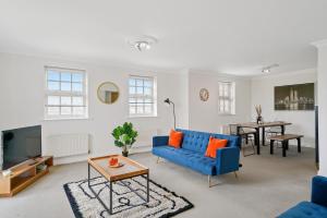 a living room with a blue couch and a table at Stylish Central York Duplex Penthouse in York