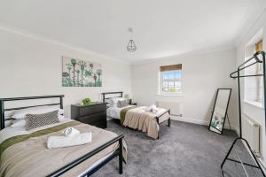 two beds in a room with white walls at Stylish Central York Duplex Penthouse in York