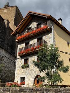 a building with flower boxes and balconies on it at Casa rural ELURKOIA in Isaba