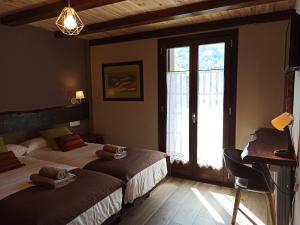 a bedroom with two beds and a window at Casa rural ELURKOIA in Isaba