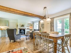 a dining room and living room with a table and chairs at Chasewoods Farm Cottage in Ogbourne Saint George