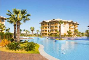 a resort with a large swimming pool with palm trees at Vg Sun Cumbuco C5 106 in Caucaia