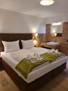 a bedroom with a large bed with towels on it at Hotel Alpenhof*** in Kaltenbach +62 photos