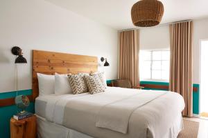 a bedroom with a large white bed and a window at Cambria Beach Lodge in Cambria