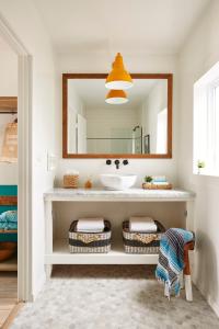 ein Bad mit einem Waschbecken und einem Spiegel in der Unterkunft Cambria Beach Lodge in Cambria
