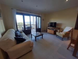 a living room with a couch and a television at Sol y Mar in Cala Ratjada