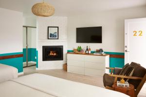 sala de estar con TV y chimenea en Cambria Beach Lodge, en Cambria