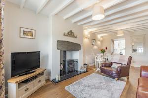 a living room with a fireplace and a tv at 2 Bryn Tirion in Tanygrisiau