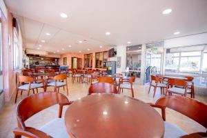Hotel Paraimo في ألانثاذا: غرفة طعام مع طاولات وكراسي ومطعم