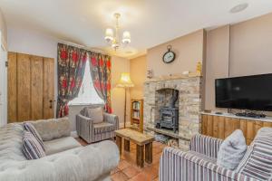 a living room with a fireplace and a tv at Fisher Cottage in Hornsea