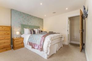 a bedroom with a bed and a dresser and a tv at Fisher Cottage in Hornsea