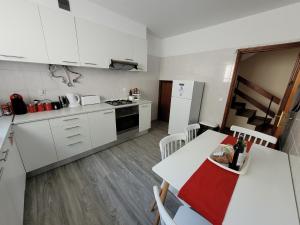 una cucina con elettrodomestici bianchi, tavolo e sedie di Casa Alegria a Funchal
