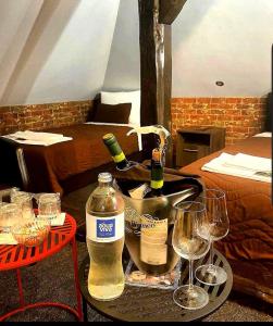 a table with two glasses and bottles of wine at Hotel rooms & Restaurant Pirocanac in Pirot