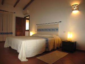 een slaapkamer met een bed en een lampje aan de muur bij Il Vecchio Ginepro in Arzachena