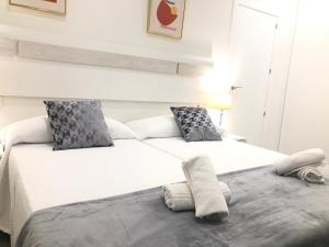 2 camas en un dormitorio con sábanas y almohadas blancas en Apartamento Air Blanc Maracena Centro, en Maracena