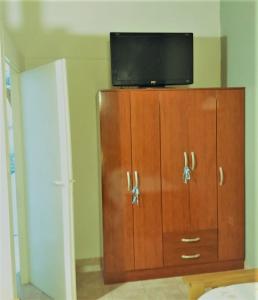 a flat screen tv on top of a wooden cabinet at EL AURA in Federación