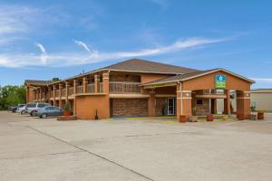 a hotel building with cars parked in a parking lot at SureStay Hotel by Best Western Rockdale in Rockdale