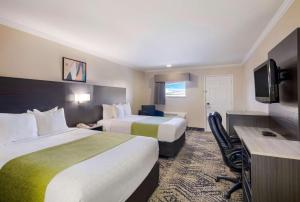 a hotel room with two beds and a flat screen tv at SureStay Hotel by Best Western Rockdale in Rockdale