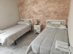 RozasにあるEntrecastañosのベッドルーム1室(ベッド2台、ランプ付きテーブル付)