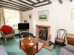 a living room with a fireplace and a tv at 89 High Street in Kirkby Stephen