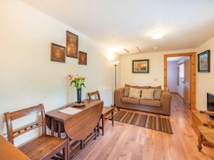 a living room with a table and a couch at Cilwen Fach in Abernant