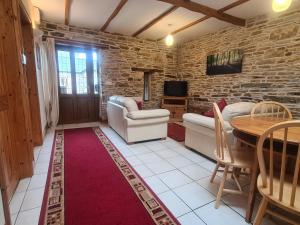 a living room with a couch and a table at Sandpiper Cottage in Llanboidy