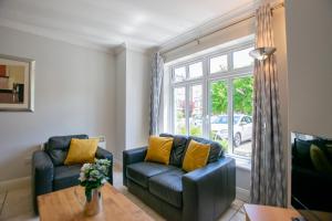 a living room with two blue couches and a window at 137 - The Townhouse at Gort Na Coiribe By Shortstays in Galway