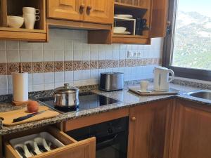 a kitchen with wooden cabinets and a stove top oven at APARTAMENTOS SERRELLA - Rural Guadalest in Benimantell