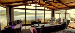 uma sala de estar com uma grande vista para um lago em Titicaca Lodge Peru em Puno