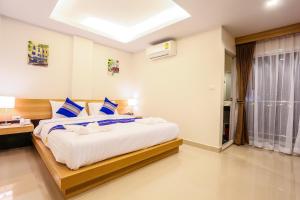 a bedroom with a large bed with blue and white pillows at PKL Residence in Patong Beach