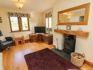 a living room with a television and a mirror at Horton Scar House in Horton in Ribblesdale