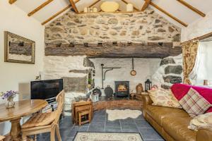 a living room with a couch and a fireplace at Y Becws in Llanbedr