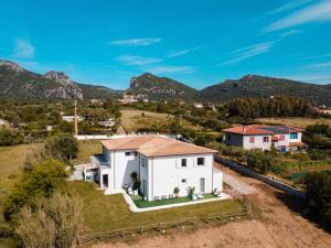 une vue aérienne sur une maison blanche avec des montagnes en arrière-plan dans l'établissement Agriturismo b&b Mares e Montes de Marrante, à Siniscola