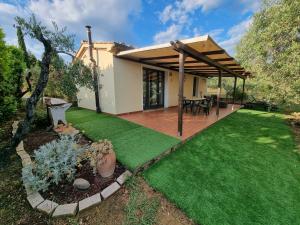 a backyard with a wooden deck and green grass at Vigna Lontana in Montescudaio