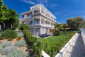 a large white house with a garden in front of it at Villa Velvet in Villeneuve-Loubet