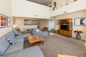 a living room with a couch and a tv at The Sandbridge Dunes - Captains' Quarters 408 in Virginia Beach