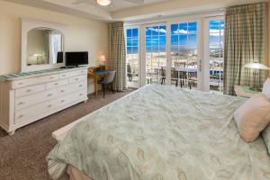 バージニアビーチにあるThe Sandbridge Dunes - Captains' Quarters 408のベッドとテレビとバルコニーのある寝室 +35枚の写真