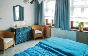 a bedroom with a blue bed and a dresser and windows at Nine-Bedroom Holiday Home In Petershagen Ot Frille in Frille