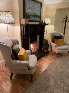 a living room with two chairs and a fireplace at Dun Ri Guesthouse in Clifden