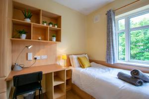 una camera con 2 letti, una scrivania e una finestra di 126 - Gort Na Coiribe 4 Bedroom Duplex, by Shortstays a Galway