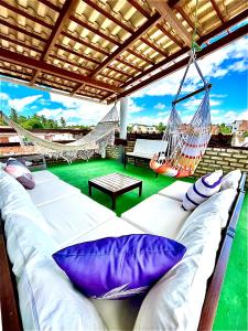 a porch with a hammock and a swing at Villa Flecheiras in Flecheiras +24 photos