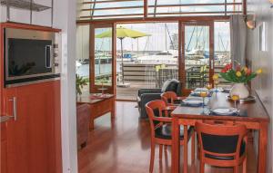 a dining room with a table and chairs and a marina at Bungalowpark Wijdland-aak in Bunschoten