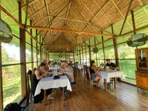 a group of people sitting at tables in a restaurant at Estancia Bello Horizonte in Puerto Maldonado
