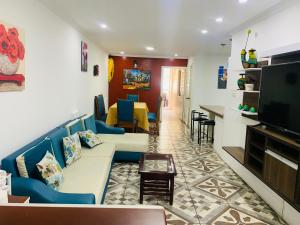 a living room with a couch and a tv at Confort Home C Apartamento Girasol in Baños
