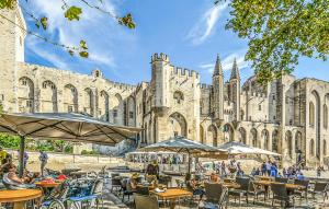 een gebouw met tafels en parasols voor een gebouw bij Beautiful Apartment In Remoulins With Wifi in Remoulins